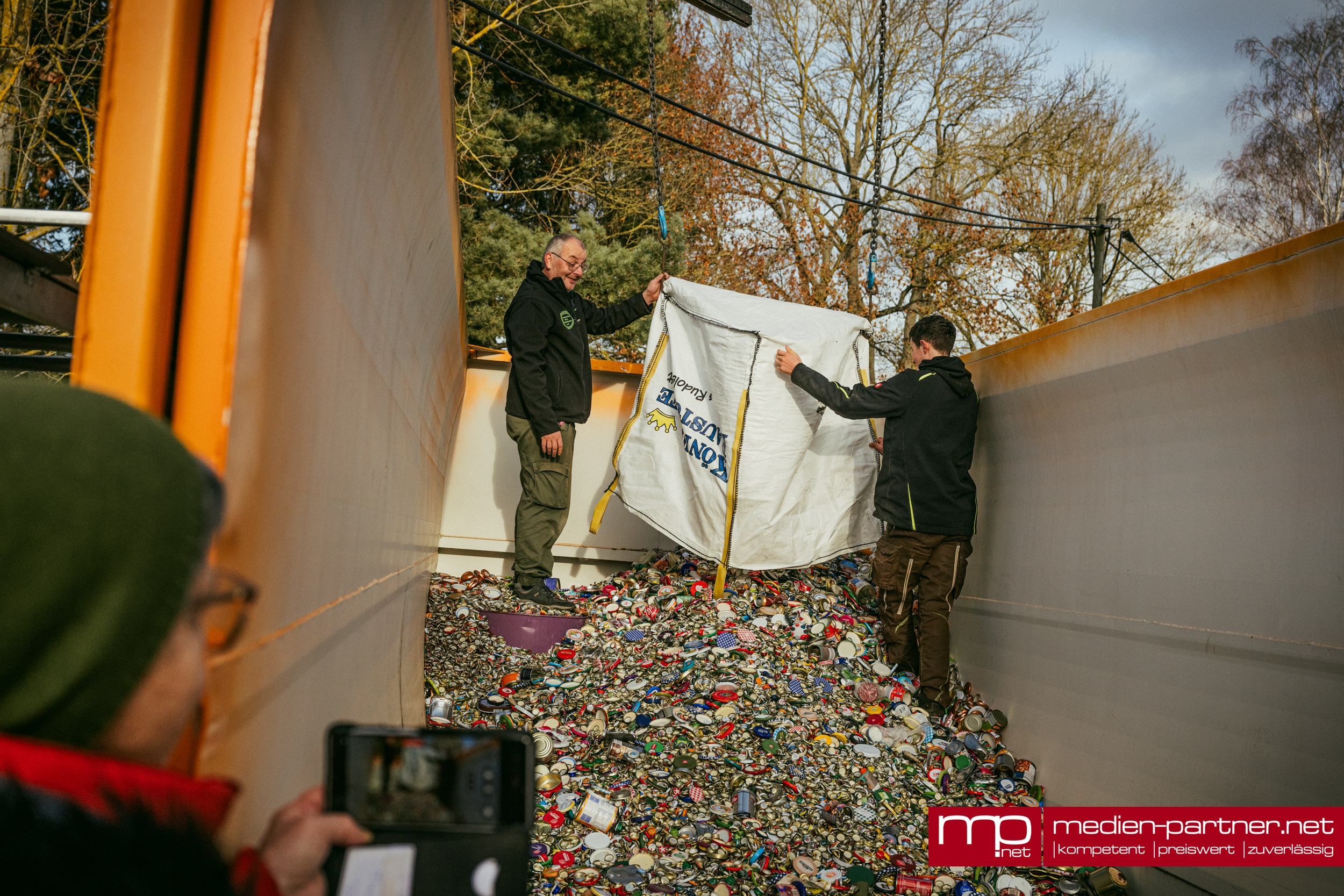 Container mit Millionen Blechdeckeln gefüllt